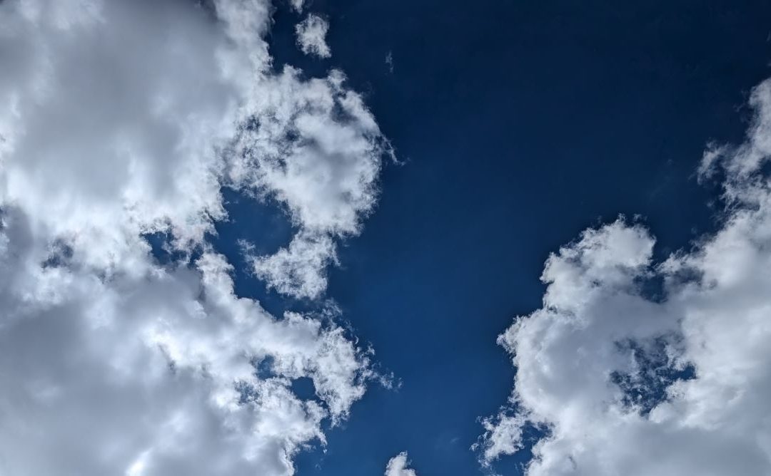 blue sky filled with white clouds limned with sunlight